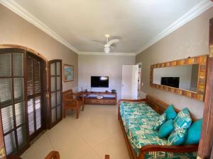 a living room with a couch and a television at Casa Três Amores in Búzios