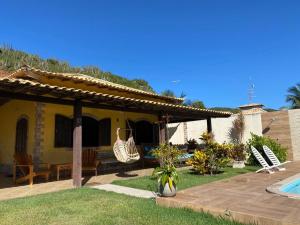 a house with a patio and a swimming pool at Casa Três Amores in Búzios