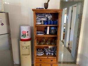 a wooden shelf in a kitchen next to a refrigerator at Casa Três Amores in Búzios