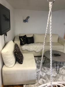a living room with a white couch and a swing at Apartment Amra in Sarajevo