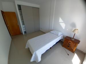um quarto com uma cama e uma mesa com um candeeiro em Departamento en Corrientes em Corrientes