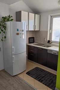 a kitchen with a white refrigerator and a sink at Apartments with parking space Makarska - 6850 in Makarska