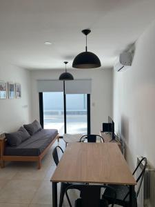 sala de estar con mesa y sofá en Departamento moderno con parrilla privada para 3 en Salta