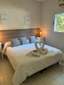 Un dormitorio con una cama grande con un corazón. en Las Lomas Suites & Spa en Chascomús