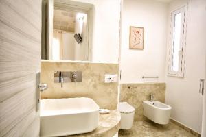 łazienka z umywalką, wanną i toaletą w obiekcie AFFITTACAMERE I PACIORRA w mieście Favignana