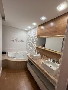 a bathroom with two sinks and a bath tub at Estadia na Canção Nova in Cachoeira Paulista