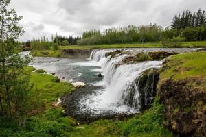 a waterfall on the side of a river at Heiðarbrún in Hveragerði