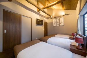 a bedroom with two beds and a tv in it at RESI STAY NISHIKI in Kyoto