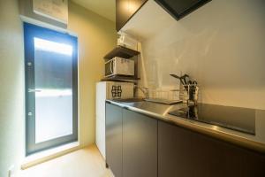a kitchen with a sink and a microwave at RESI STAY NISHIKI in Kyoto