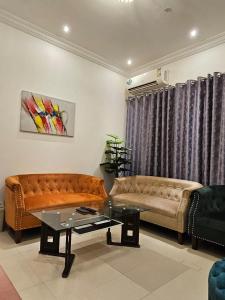 a living room with two couches and a table at تاج الكورنيش عجمان in Ajman 