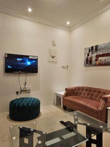 a living room with a couch and a tv at تاج الكورنيش عجمان in Ajman 