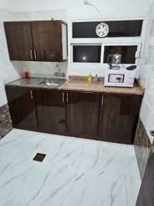 a small kitchen with a sink and a microwave at تاج الكورنيش عجمان in Ajman 