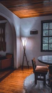 uma sala de estar com uma mesa e um candeeiro em Chalé das Montanhas - Cachoeira particular dentro da hospedagem em Nova Friburgo