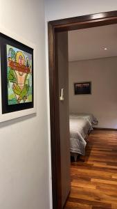 a room with a bed and a painting on the wall at Madre Natura in Asuncion