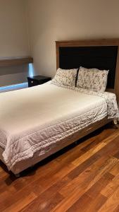 a bed in a bedroom with a wooden floor at Madre Natura in Asunción