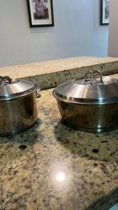 two metal pots sitting on a counter top at Madre Natura in Asuncion
