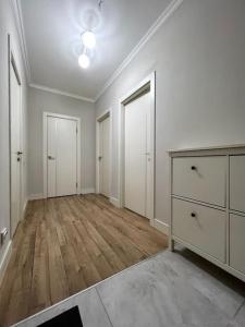 um quarto vazio com paredes brancas e pisos em madeira em Жк «Abay 130» комфорт и уют em Almaty