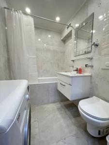 uma casa de banho branca com um WC e um lavatório em Жк «Abay 130» комфорт и уют em Almaty