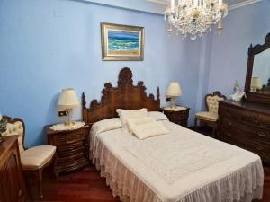 a bedroom with a bed and two chairs and a chandelier at Spacious house with pool and garden in Congosto in Congosto
