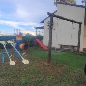 特林达迪SONHO DE CHACARA PIQUIA II的一个带秋千和滑梯的游乐场