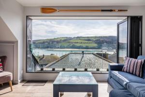 a living room with a couch and a large window at 2 Church Hill House in Salcombe