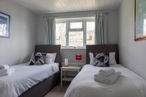 1 dormitorio con 2 camas y ventana en 2 Church Hill House, en Salcombe