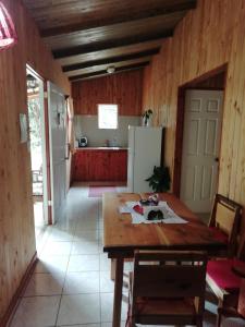 a kitchen with a wooden table and a refrigerator at Miriam'S Quetzals lodge in San Gerardo de Dota