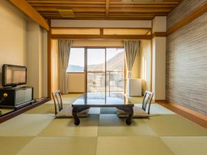 笛吹市的住宿－Japanese Onsen Ryokan Kohakuen，一间带桌子和大窗户的用餐室