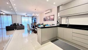 eine Küche und ein Wohnzimmer mit einem Tisch, einer Küche und einem Esszimmer in der Unterkunft Viva em um Resort Paradisíaco na Brava 100m do Mar in Itajaí + 59 Fotos