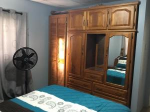 um quarto com um armário de madeira e uma cama em Foothills Apartment 28 Vacation Nest em San Fernando
