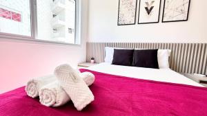 ein Schlafzimmer mit einem großen Bett mit einer rosa Decke in der Unterkunft Viva em um Resort Paradisíaco na Brava 100m do Mar in Itajaí