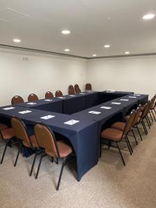 een lange blauwe tafel en stoelen in een kamer bij JP Crauford Hospedagem in Sao Paulo
