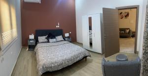1 dormitorio con 1 cama grande y 1 silla en résidence zeineb, en Nouakchott
