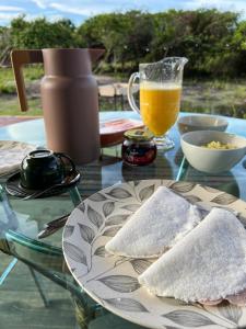 een tafel met een bord eten en een glas sinaasappelsap bij Green Village pousada Atins in Atins