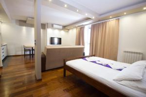 a bedroom with a bed and a couch and a table at Vila Centar in Budva