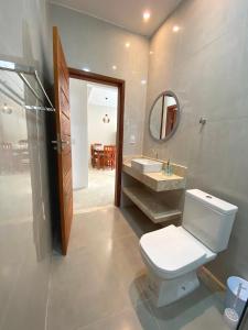 uma casa de banho com um WC, um lavatório e um espelho. em Casa do Villas - Arraial d'Ajuda em Arraial d'Ajuda