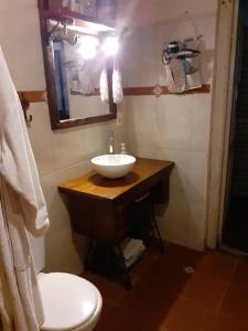 W łazience znajduje się umywalka, toaleta i lustro. w obiekcie INFINITO YO, espacio pensado para mujeres solas o con su pareja w mieście Carmelo