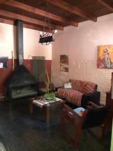 salon z kanapą i kominkiem w obiekcie INFINITO YO, espacio pensado para mujeres solas o con su pareja w mieście Carmelo