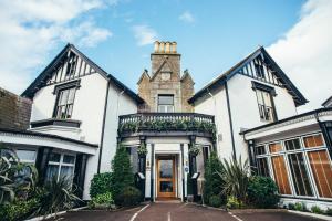 una gran casa blanca con torreta en Palm Court Hotel en Aberdeen