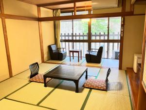 a living room with a coffee table and chairs at Hotel Yunishigawa in Nikko