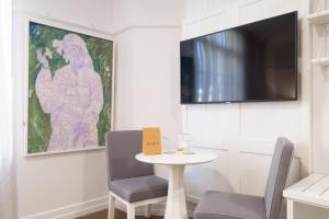 a small table with two chairs and a tv on a wall at Ciao Bella in Brisbane