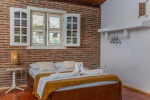2 Betten in einem Zimmer mit Ziegelwand in der Unterkunft casa jasmin in Jericoacoara