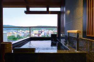 a bath tub with a view of a city at Sora Niwa Terrace Kyoto Bettei in Kyoto