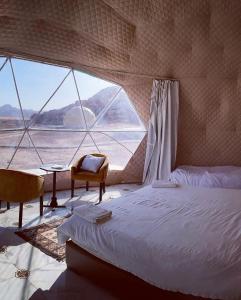 a bedroom with a bed and a large window at Salma Desert Camp in Wadi Rum