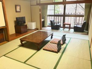 a living room with a coffee table and chairs at Hotel Yunishigawa in Nikko