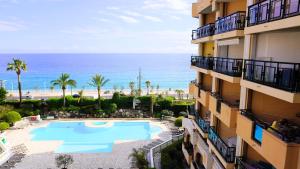 an apartment building with a swimming pool and the beach at Appartement 556, Vue Mer et piscine By Palmazur Vacances in Cannes