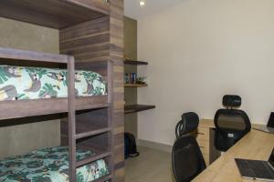 - une chambre avec des lits superposés et un bureau avec un ordinateur portable dans l'établissement Casa Kaiman - Villa Azul, à Nosara