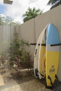 deux planches de surf sont garées à côté d'un mur dans l'établissement Casa Kaiman - Villa Azul, à Nosara