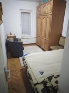 um quarto com uma cama e duas cadeiras e uma janela em Kraljevski apartman em Kraljevo