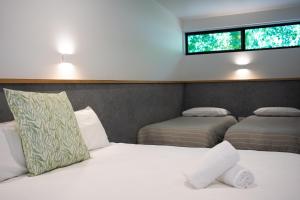 a bedroom with two beds and two windows at Harrietville Hotel Motel in Harrietville